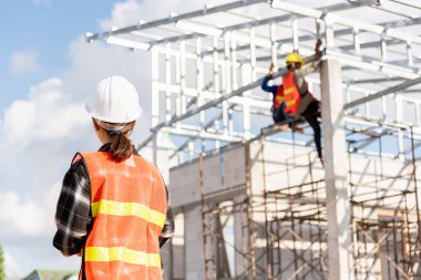 Bir mimar ev inşaatının önünde dikiliyor. Asyalı mühendis ustabaşı kadın, Ev yapımı Proje Kalite Denetleme