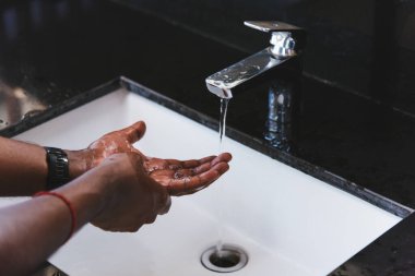 Siyah adamın ellerini yıkamak lavaboya sabun ve suyla ovmak salgın koronavirüsünün virüs yaymasını önlemek için, COVID-19 konseptini karantina temizliği için hijyen.