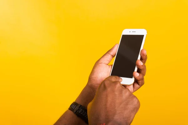 閉じるアジアの幸せな肖像画若い黒人男性が手にデジタル携帯電話のスマートフォンの空白の画面スペースを保持し 黄色の背景に隔離されたスタジオ — ストック写真