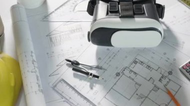 Mimari işyeri üst görünümü. Mimari proje planları masa üzerinde, mühendislik müteahhitlerinin tasarım için araç çalışma çizimi ve VR gözlükleri, sanayi sanal teknolojisi