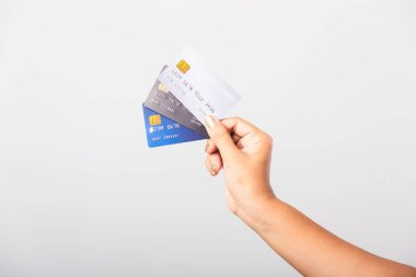 Asyalı kadının elini kapat. Banka kredi kartını elinde tutuyor. İnternetten alışveriş yapıyor, stüdyo resmi beyaz arka planda izole edilmiş.