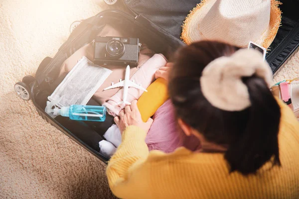 Preparing for travel in new normal. Woman packing clothes in luggage for new journey, Preparation travel suitcase at home, Travel vacation traveling after quarantine coronavirus pandemic concept