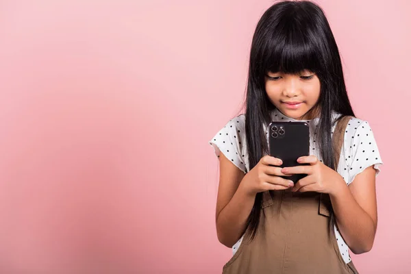stock image Asian kid 10 years enjoying using mobile phone for social network media at studio shot isolated on pink background, Happy child girl lifestyle using smartphone, typing message chatting with friend