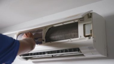 Profesyonel teknisyen erkek, çamaşır yıkamak için kirli klima filtresi temizleme ve yıkama, evde temizlik ve onarım işi yapan, sağlıklı yaşam için toz ve kir temizleyen adam.