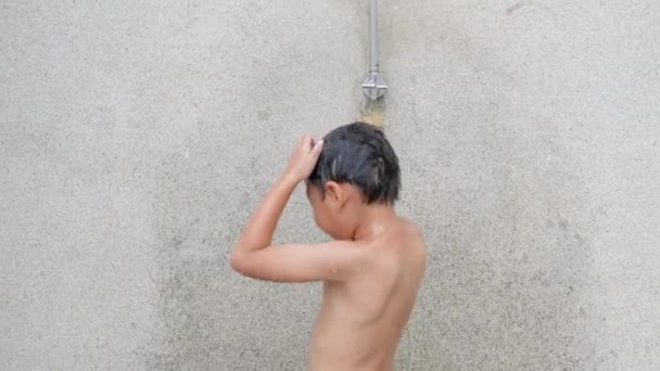 アジアの子供の男の子はスイミングプールリゾートでシャワーを浴びて 幸せな子供彼は家族の夏休みの間に熱帯リゾートで清々しい体と衛生をきれいに泳いだ後 — ストック動画
