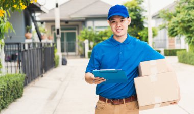Üniformalı Asyalı genç kurye paket posta kutuları servis sevkiyatı, yürüyüş ve müşteri ev konumu, çevrimiçi alışveriş hizmeti kavramları arama