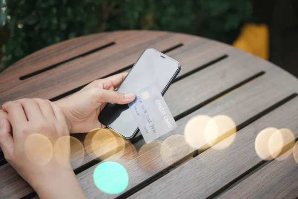 Close up hand of woman using credit card and smartphone during slide screen for finding product purchase buying payments online shopping, making secure internet payment browsing banking service