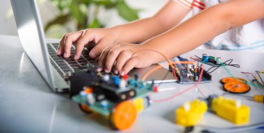 Asian kid boy learns coding and programming with laptop for Arduino robot car, Little child students typing code in computer online with car toy, STEAM education AI technology future course learning clipart
