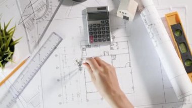 Mimari proje işyeri. Mimarlık bürosundaki masa masasında tamir aletleri için pusula üzerine pusula çizen mimar, inşaat projesi çizen mühendis.