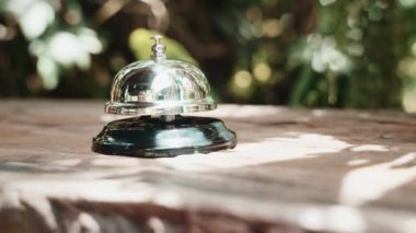 Misafirperver otel. Kahve dükkanındaki müşteri el zili, menüyü almak için çalışanları aradığı için kadın parmağı zile dokunduğu için.