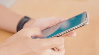 Akıllı telefondan başvuru yapan bir kadın sosyal medyada posta okuyor ahşap teble 'da, mutlu kadın parmak slayt modern cep telefonu ekranı, online internet araması