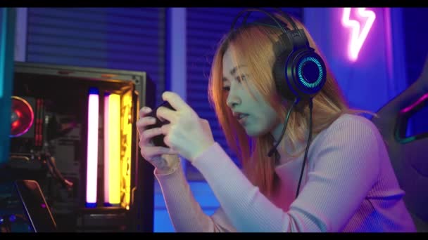 Azjatka Gracz Nosi Słuchawki Gier Trzymając Joystick Konsoli Gry Wideo — Wideo stockowe