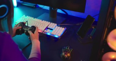 Close up hands, Joystick console in hands of gamer playing games computer online and fun at home colorful fashion neon, gaming with gamepad controller she press the game button, E-Sport concept