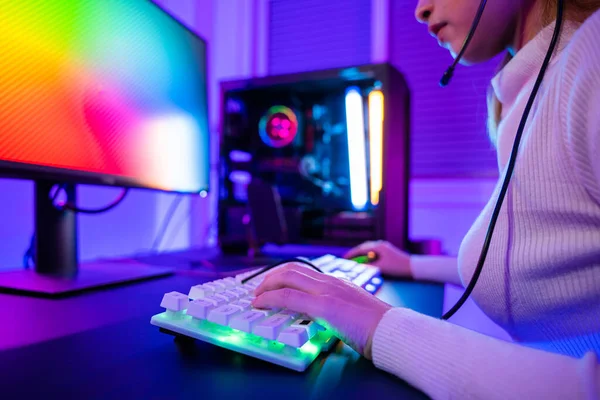 Close up gamer hands actively pushing buttons with colorful neon LED lights, woman guy typing on his gaming keyboard and mouse to playing some game in dark room using, E-sport concept