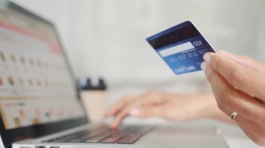 Online shopping. Woman hands holding credit card and using laptop with product purchase at home, female register via credit cards on computer to make electronic payment security online