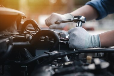 Service outdoor. Close up hands of auto mechanic man working on car engine using wrench to repair and maintenance, broken car care check and fixed the problem and services insurance