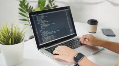 Programmer woman writing program HTML code sitting at workplace in office, IT software developer hands typing data coding programming with laptop computer, IT start up concept, Web application design