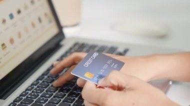 Online shopping. Woman hands holding credit card and using laptop with product purchase at home, female register via credit cards on computer to make electronic payment security online