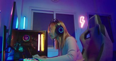 Oyun bitti. Çevrimiçi oyun oynayan Asyalı oyuncu kaybediyor ve üzgün, bilgisayar ekranında renkli LED ışıklar, oyun kulaklığı takan kadın, kaybettiği oyun için hayal kırıklığına uğruyor, E-Sport