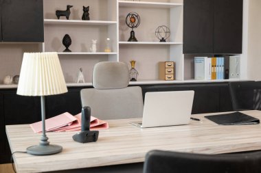 Laptop bilgisayarlı ahşap masanın yanında rahat bir ofis sandalyesi ofis masasının içinde çalışma odası, kimse boş kalmasın.
