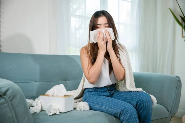Ill Asian Young Woman Cold Covered Blanket Sitting Sofa Sneeze — Fotografia de Stock