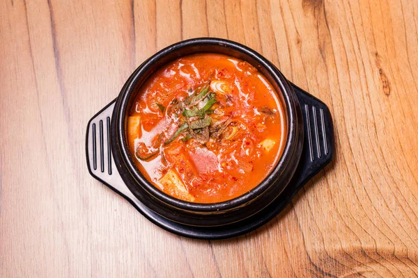 Kimchi soup in hot black iron pot, Korean traditional Kimchi Jjigae soup in bowl in the restaurant, Japanese hot pot food