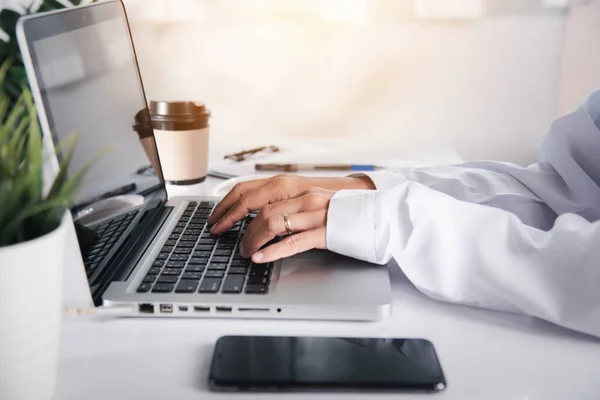 Hands of female doctor wear uniform in hospital she typing information on keyboard laptop, nurse working using computer browsing internet, Healthcare medical health website technology online data