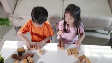 Children boy and girl playing with constructor wooden block building, Happy little kids play wood block stacking board game at home, activities learning creative, toys for preschool and kindergarten