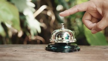 Misafirperver otel. Kahve dükkanındaki müşteri el zili, menüyü almak için çalışanları aradığı için kadın parmağı zile dokunduğu için.