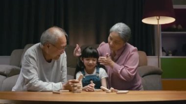 Doğum günü sürprizi. Mutlu Asyalı aile büyükbabaları ve anneleri kutlama yapıyor. Torunlarının pastasıyla evde eğleniyorlar.