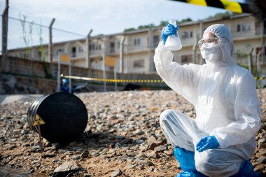 Nehirden su örneklerini test tüpü camlarıyla alan ekolojist, beyaz dumana sahip. Biyolog, zehirli kimyasallardan, bilim adamlarından ve sorunlu çevreden örnekler topluyor.