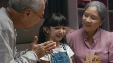 Doğum günün kutlu olsun. Asyalı aile büyükbabası ve büyükannesi torununu öptüler. Doğum gününü kutlarken minnet duyuyorlardı. Evde çocuklu bir aile partisi vardı.
