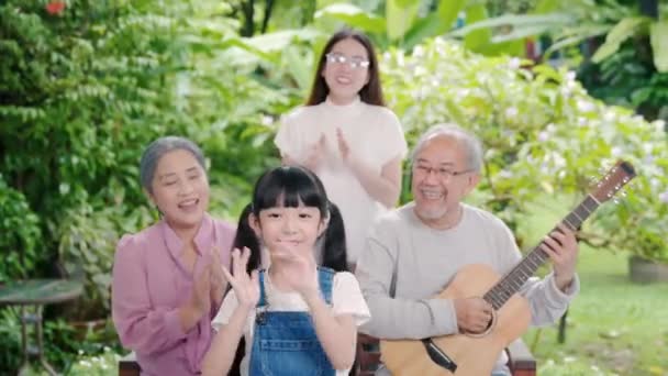 快乐家庭亚洲老年男子或祖父在户外弹吉他 祖母和孙女在户外一起唱歌 活动家庭 享受老年生活 — 图库视频影像