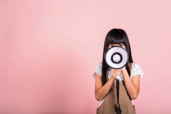 분홍색 배경으로 고립된 스튜디오에서 메가폰으로 외치는 아시아인 아동복 소녀의 — 스톡 사진