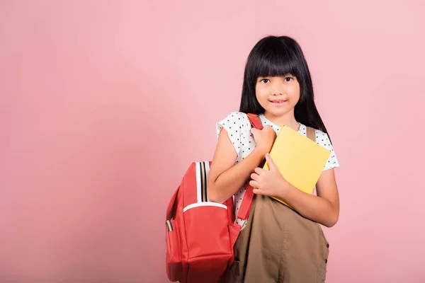 アジアの小さな子供10歳でバックパックは 学校に戻る準備ができていますで撮影したスタジオでのショット白い背景に隔離されました 幸せな子供の女の子の肖像とともに学校のバッグと保持または巨大な本 — ストック写真