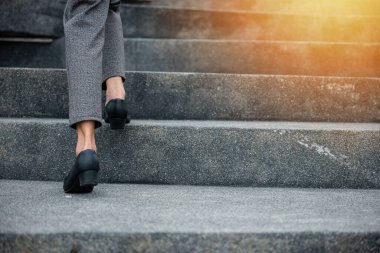 Stepping going up stairs in city, Closeup legs of businesswoman hurry up walking on stairway, rush hour to work in office a hurry in morning, foot of business woman wear black shoes step up success