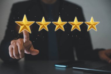 Altın beş yıldızlı kalite değerlendirmesi. İşadamı en iyi internet pazarlaması için beş yıldızlı bir sembolü işaret ediyor.