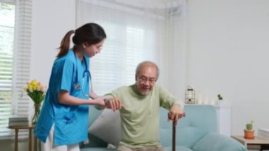 Yaşlılar için Uluslararası Gün. Genç bakıcı, yaşlı bir adamın kanepede ayağa kalkmasına yardım ediyor mavi üniformalı hemşire, yaşlı ve yaşlı bir adamın bastonuyla yürümesine yardım ediyor.