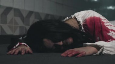 Korkunç Asyalı, tüyler ürpertici sürünen, tüyleri diken diken olmuş, elinde kanla yüzünü örten korkunç Asyalı kadın zombi.