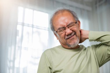 Evde boynu ağrıyan yaşlı bir adam, akut boyunlu yaşlı bir adam, boynunu tutan üzgün yaşlı bir adam, yaşlılık emekliliği sorunları sağlıksız hastalıklar, omuz ağrısı.