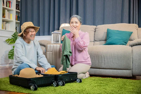기사보기 아시아의 노부부가은 여행을 가방을 준비하고 로맨틱하게 거실의 바닥에서 가방을 — 스톡 사진
