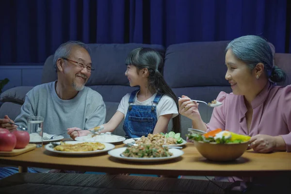 아시아인 가족의 조부모와 손녀가 식탁에서 식사하고 시간에 즐거운 시간을 보내는 — 스톡 사진