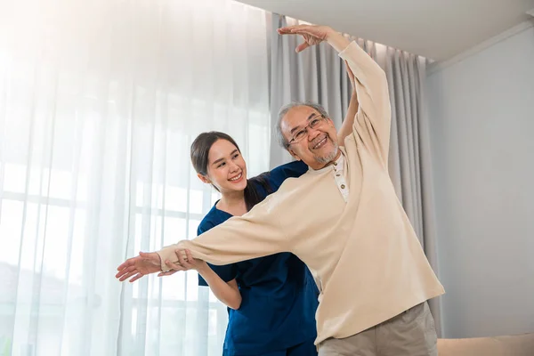 Old Senior Man Enjoys Training Physiotherapist Outstretched Arms Home Asian — 스톡 사진