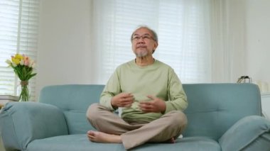 Yaşam tarzı sakin, son sınıf öğrencisi Lotus poz veriyor. Akli denge için yoga yapıyor. Kanepede dinleniyor, Asyalı yaşlı adam yoga ve meditasyon yapıyor.