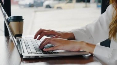 Kafede dizüstü bilgisayar kullanan Asyalı genç iş kadını yaşam tarzı dizüstü bilgisayarı dizüstü bilgisayarda klavye yazan, ofis dışında çalışan mutlu, serbest yazar.