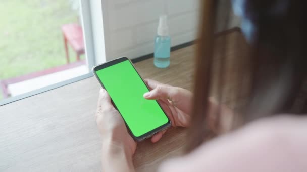 在咖啡店里 女性手持手机或带有空白绿色屏幕的手机靠在一起看新闻 女性则在社交媒体上使用智能手机 — 图库视频影像