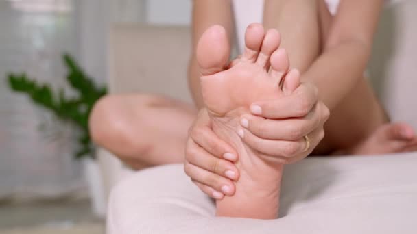 坐在沙发上的亚洲女人在家里感到脚痛 患有脚痛的女人用手压放松鞋底上的肌肉 医疗保健和足部医疗 — 图库视频影像