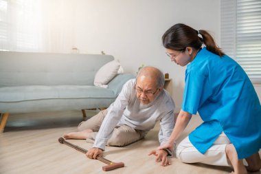 Engelli yaşlı hasta bastonuyla yere düştü ve bakım evinde asistanlık yaptı. Asyalı yaşlı adam yere düştü ve kadın hemşire oturma odasına yardım etti.