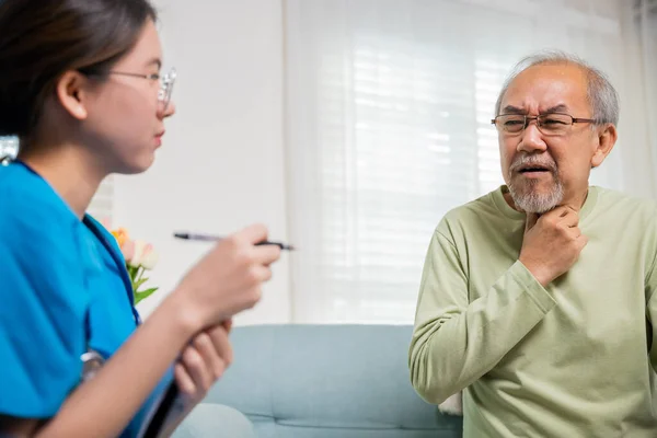 アジアの若い看護師は老人ホームでクリニックで高齢者の首の痛みをチェック 医師の女性は腫れているかどうかを判断するために首のリンパ節を調べます 喉の痛み — ストック写真