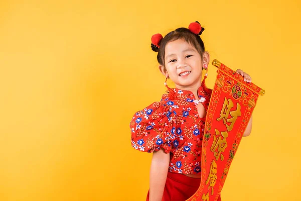 Chinese New Year. Happy Asian Chinese little child girl smile wearing red cheongsam qipao Spring festival couplets (Character \